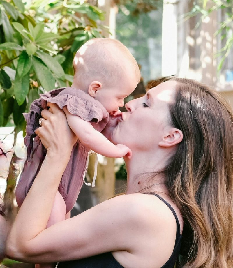 Mom kissing baby, postpartum doula support postpartum