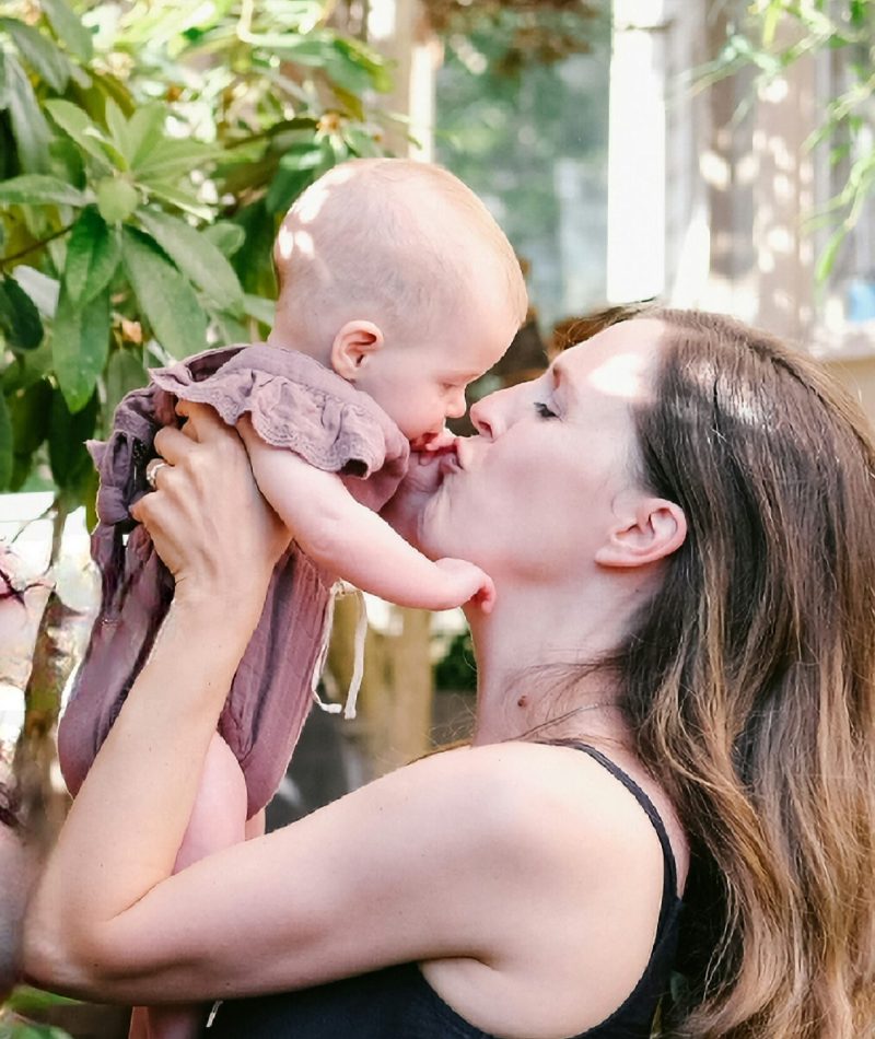 Mom kissing baby, postpartum doula support postpartum